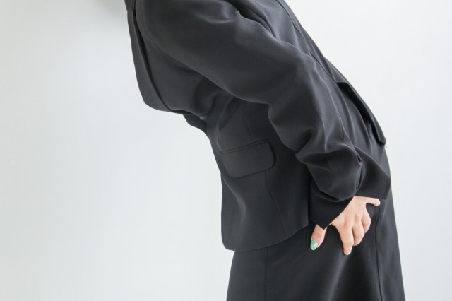 臀部を抑える女性の写真